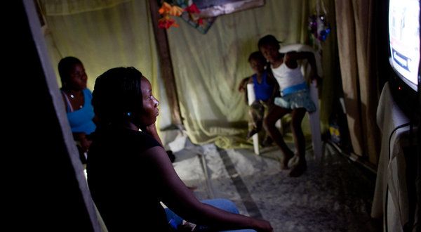 Jennifer Septimus, eine Krankenpflegeschülerin, sieht fern in ihrem Zelt in Villambeta, einem Camp in Port-au-Prince für Haitianer, die durch das Erdbeben von 2010 vertrieben wurden.