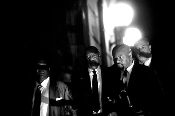 M. Cosby est entouré de son publiciste, Andrew Wyatt (à gauche), et de deux autres associés, alors qu