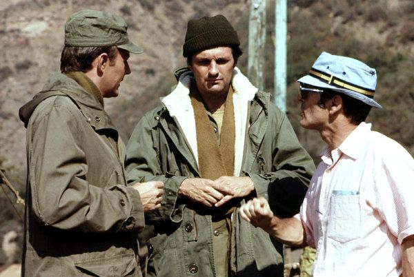 Gene Reynolds, oikealla, televisiosarjan M*A*S*H kuvauksissa, jossa näyttelijät Larry Linville, vasemmalla ja Alan Alda. Mr. Reynolds auttoi Larry Gelbartia kehittämään ohjelmaa, jota pidetään edelleen yhtenä televisiohistorian hienoimmista.